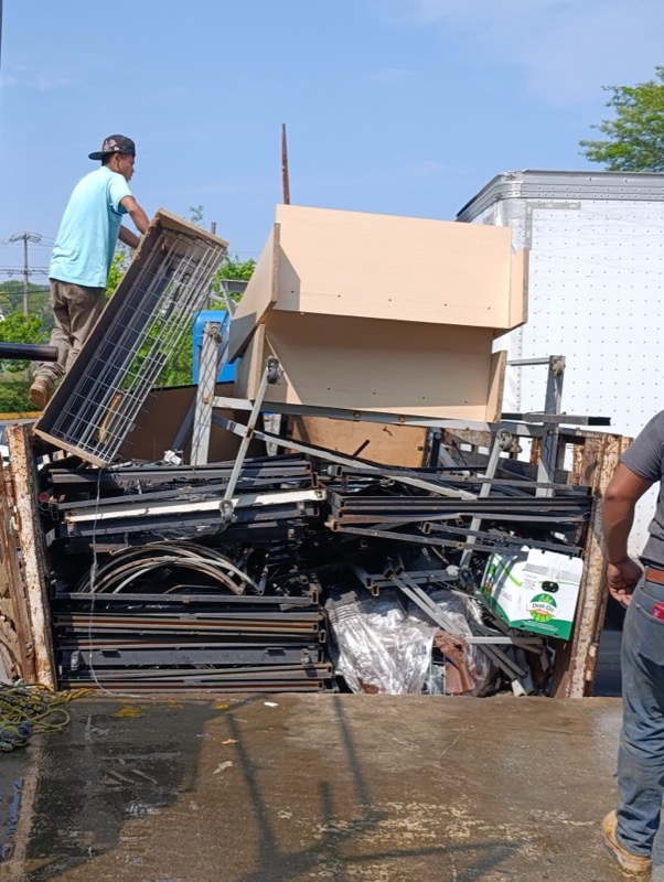 Equipo de Metalúrgica Frontier cargando mobiliario y estructura metálica en el camión de recolección