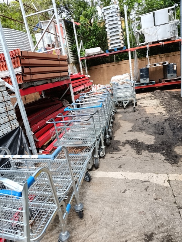 Patio de acopio con estructura de racks industriales y carritos metálicos clasificados