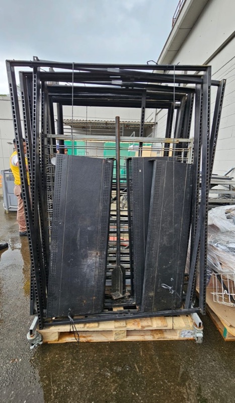Racks y estructura metálica apilados en el patio, clasificados para reciclaje